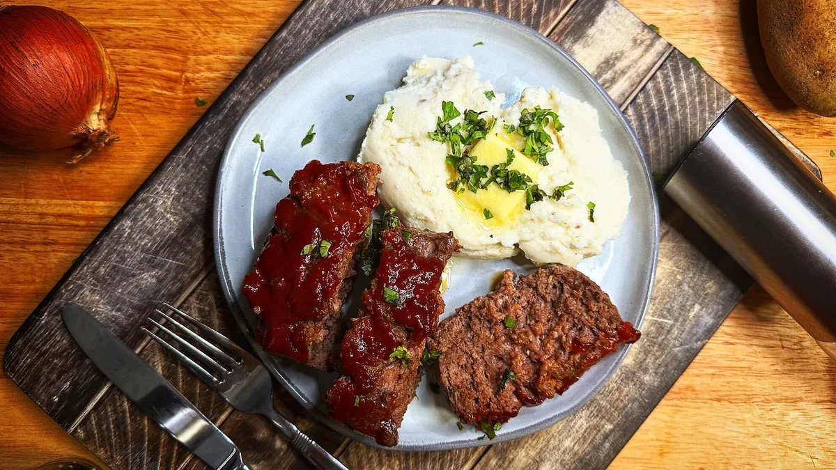 Homestyle meatloaf with mashed potatoes on a wooden table
